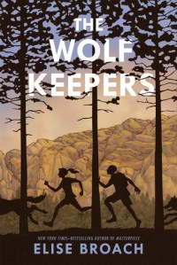 The wolf keepers boy and girl silhouette running between tall tress behind wolf