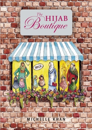 large background of brick wall. sign above shop window in middle. sign has pink lettering 'The Hijab Boutique.' window has three panels with images of ladies wearing different coloured hijabs. flowers along bottom of window and has blue panel above.