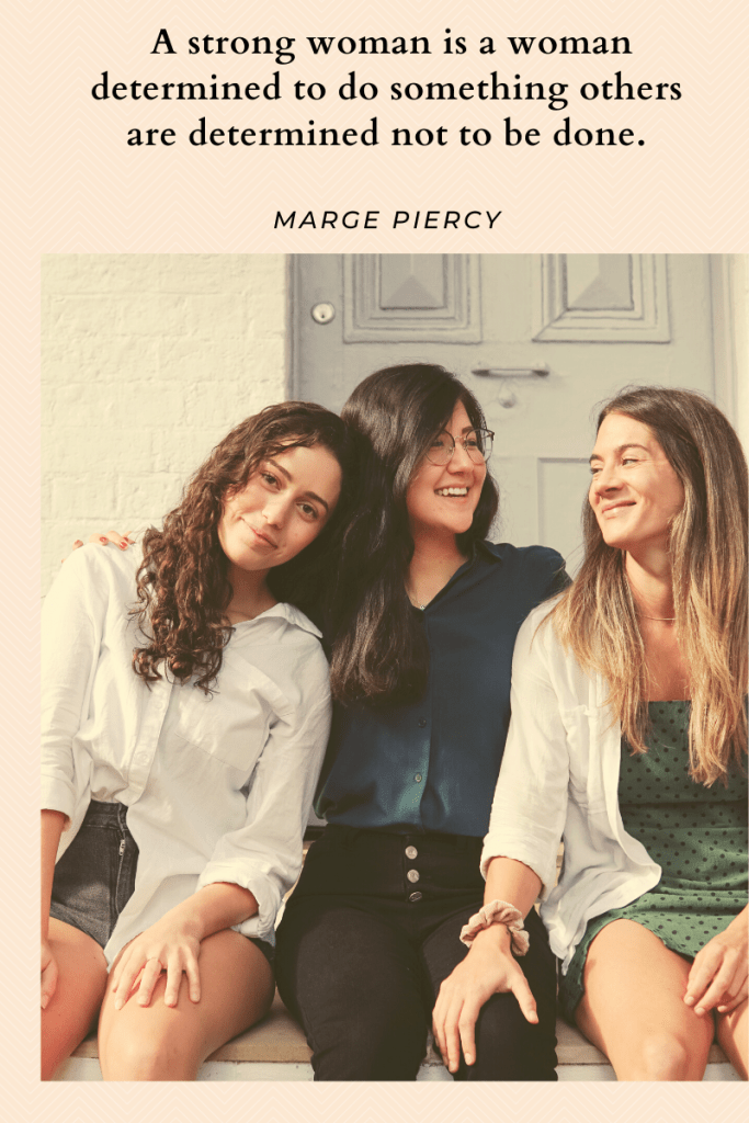 image of three women seated in front of door. all three smiling at each other in long sleeved shirts and pants. light pink background. quote in black letters across top. quote reads 'A strong woman is a woman determined to do something others are determined not to be done.' Marge Piercy.