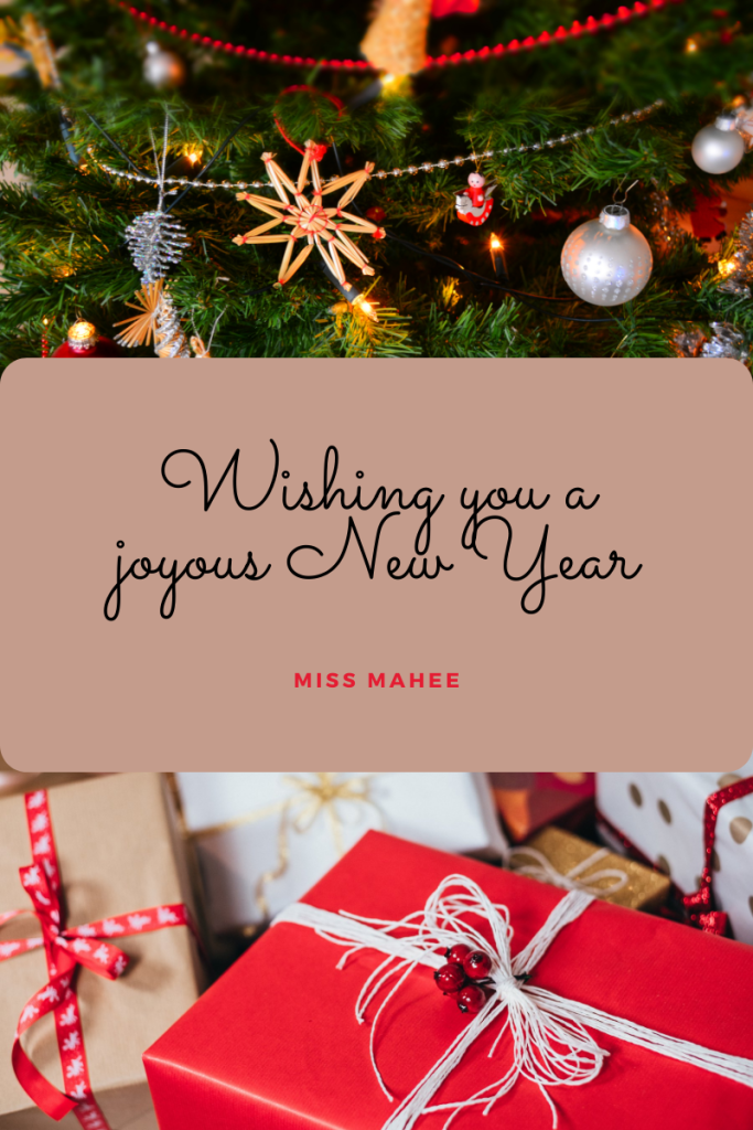 top image of decorations along Christmas tree. bottom image of wrapped gifts. light pink box in middle with black cursive letters reading Wishing you a joyous New Year and red letters reads Miss Mahee.