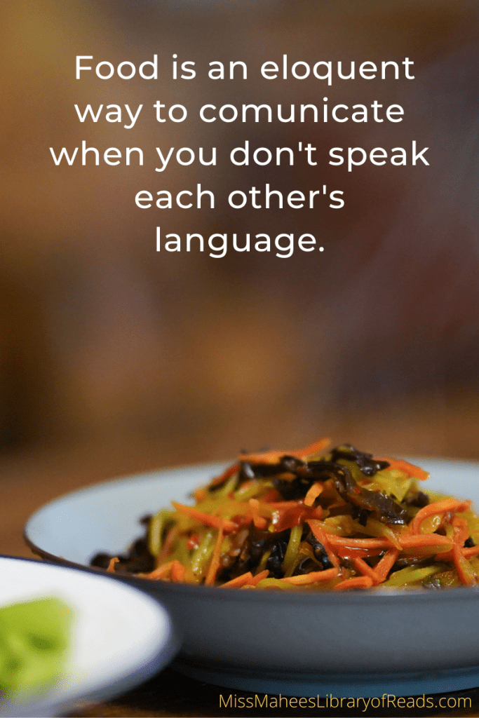 image of plate of food in white dish with orange carrot and other vegetables. faded background above. quote above reads in white letters 'Food is an eloquent way to communicate when you don't speak each other's language.'