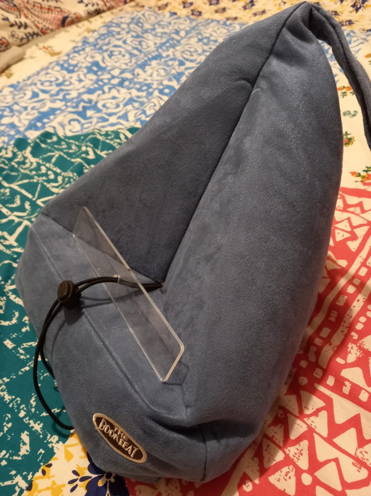 blue book seat on top of multi-coloured blanket.