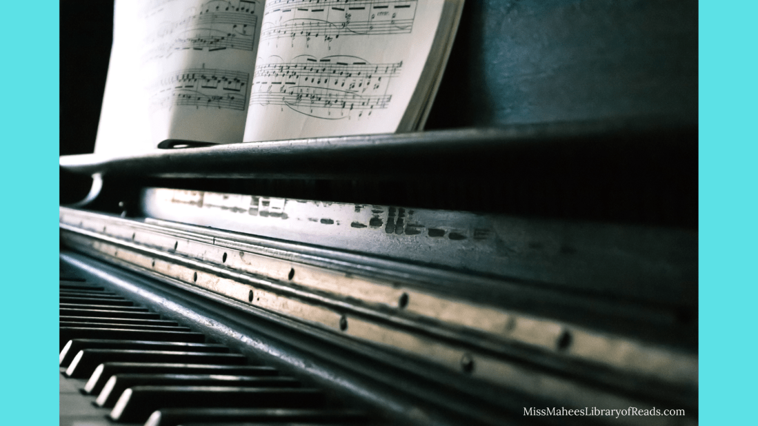 image of old piano with music score or book in middle. blue border along sides of image.