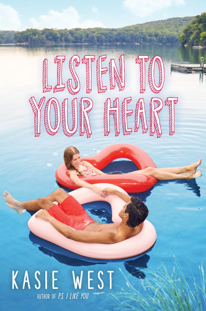 cover image of teen couple in large pink and red heart-shaped floaties/rings on lake. green trees and jetty at top. blue sky with some white clouds. pink letters above couple reads Listen to your heart.