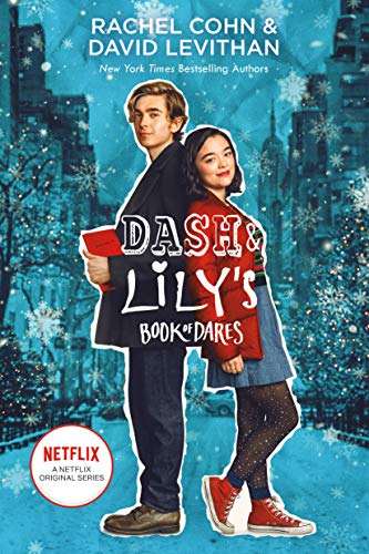 cover has photo of teen couple standing with their backs touching each other. girl is Asian with red jacket and blue dress, black tights and red sneakers. Boy is European in dark suit holding red book. behind them background is of New York City street in winter time with snowy pattern. white letters across them reads Dash & Lily's Book of Dares.