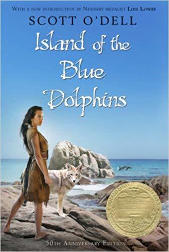 cover image of girl in brown dress with white/brown wolf standing on rocks beside sea. large rock behind them with blue sea. small dolphins in water. blue sky above. black letters at top reads Scott O'Dell. white letters beneath reads Island of the Blue Dolphins. circular gold medal on right bottom of cover.