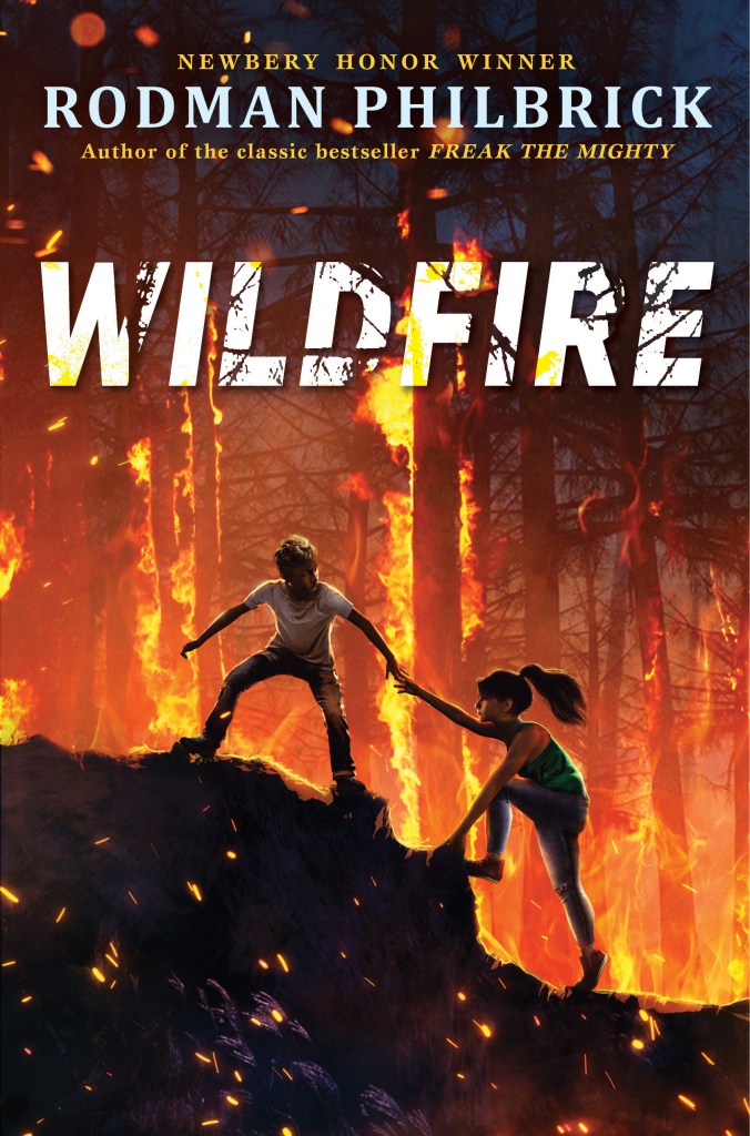cover image has boy and girl climbing up dark coloured hill. boy helps girl. large trees behind them have orange red fires between and around them. large white letters in middle reads Wildfire. smaller letters above it reads Rodman Philbrick.