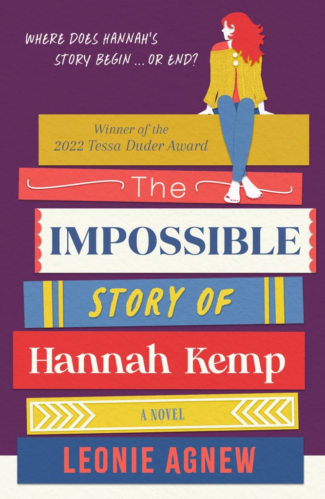 cover image has stack of book spines in middle with cartoon style image of girl with red hair in yellow jacket and jeans sitting on top of them. dark purple background. words in book spines reads from top down The Impossible Story of Hannah Kemp A Novel Leonie Agnew.