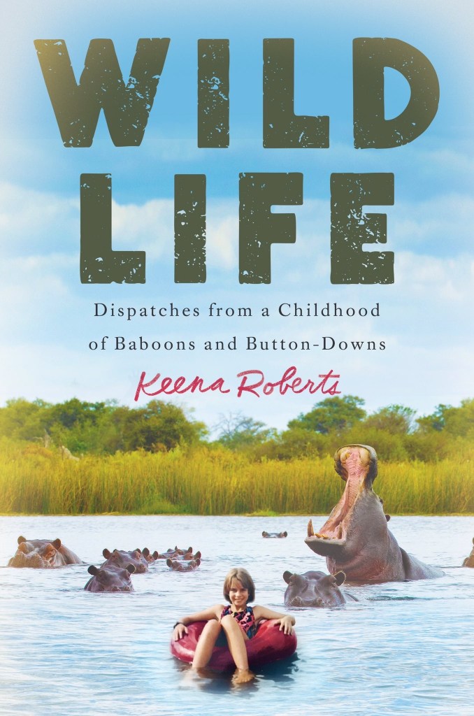 cover image has group of hippos in a river. one hippo opening mouth wide. green grass and trees behind them. small girl seated inside red rubber tyre in front of them. blue sky with soft white clouds. large green letters at top reads Wild Life. smaller letters below this reads Dispatches from a Childhood of Baboons and Button-Downs. red cursive letters below this reads Keena Roberts.