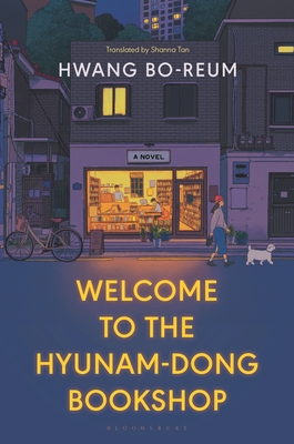 cover image of streetscape with lit up bookshop in centre and woman walking dog in right and bicycle on left of shop which has two people and shelves and tables. one lit window on floor above. high-rise building behing with lit windows and dark green tree behind. street is also dark blue, looks like night scene. large yellow letters on street reads Welcome to the Hyunam-Dong Bookshop and white letters above shop reads Hwang Bo-Reum.