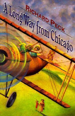 cover image has bi-plane with two people inside and one waves to two small people on ground below. below a small child in red waves while holding had of woman in dress and hat looks up. green hills underneath plane and grey clouds behind. blue letters along wings reads 'A Long Way from Chicago' and red letters above it reads Richard Peck.