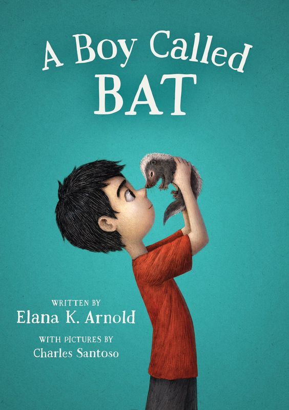 cover image has young boy in red T-shirt with dark hair holding small skunk at eye-level. green background. white letters above him reads A Boy Called BAT and smaller letters on left side reads Written by Elana K. Arnold.