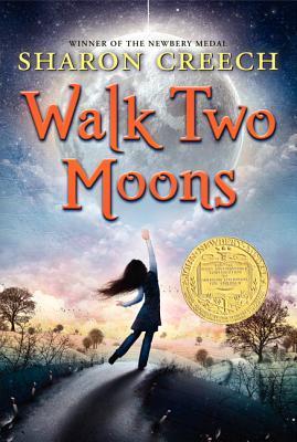 cover image has cartoon style image of girl on road. she's turned her back and reaching with one arm to sky. small trees and field on either side of dark road. sky is pink/purple at bottom and blue to dark at top. clouds make circular shape in top and large red letters across this reads Walk Two Moons. smaller yellow letters above it reads Sharon Creech. yellow circular shape in middle right of Newbery Award.